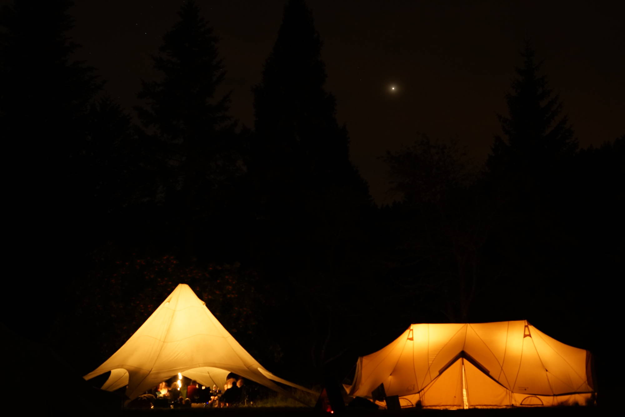 Zwei Zelte leuchten hell in die Nacht.